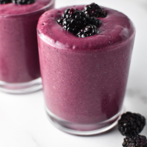 Blackberry smoothie without yogurt on a table with fresh blackberries.