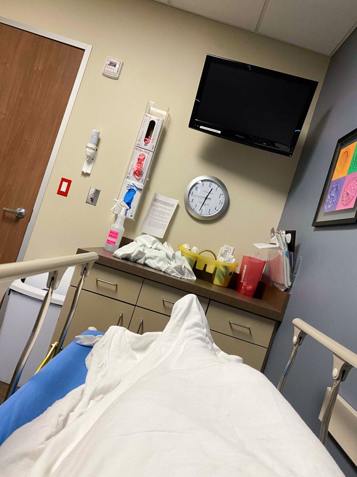 A woman lying in a hospital bed before an IVF embryo transfer