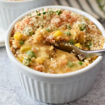 A spoon being scooped into a ramekin of crustless chicken pot pie