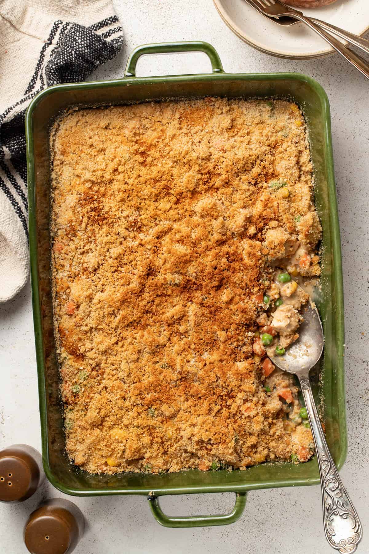 A green casserole dish filled with chicken pot pie without a crust.