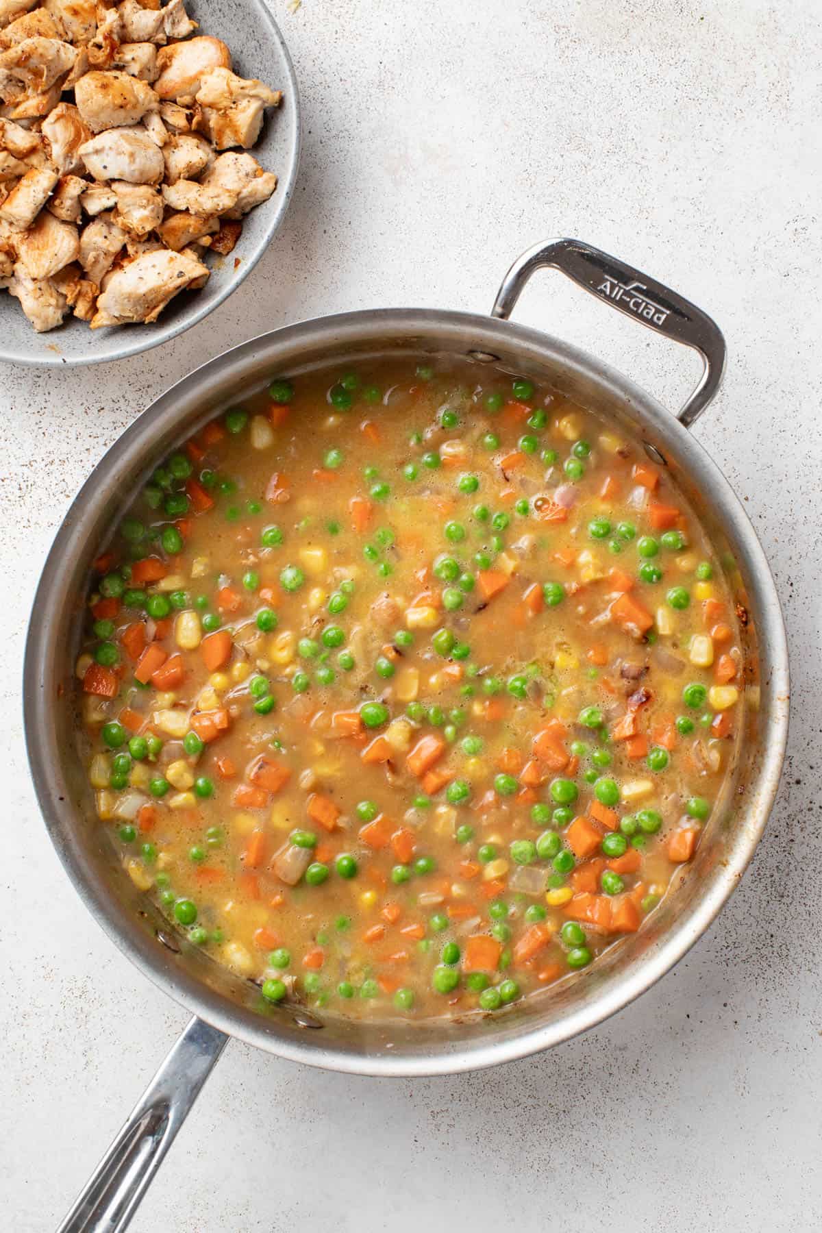Making the sauce with broth and veggies in a stainless steel pan.