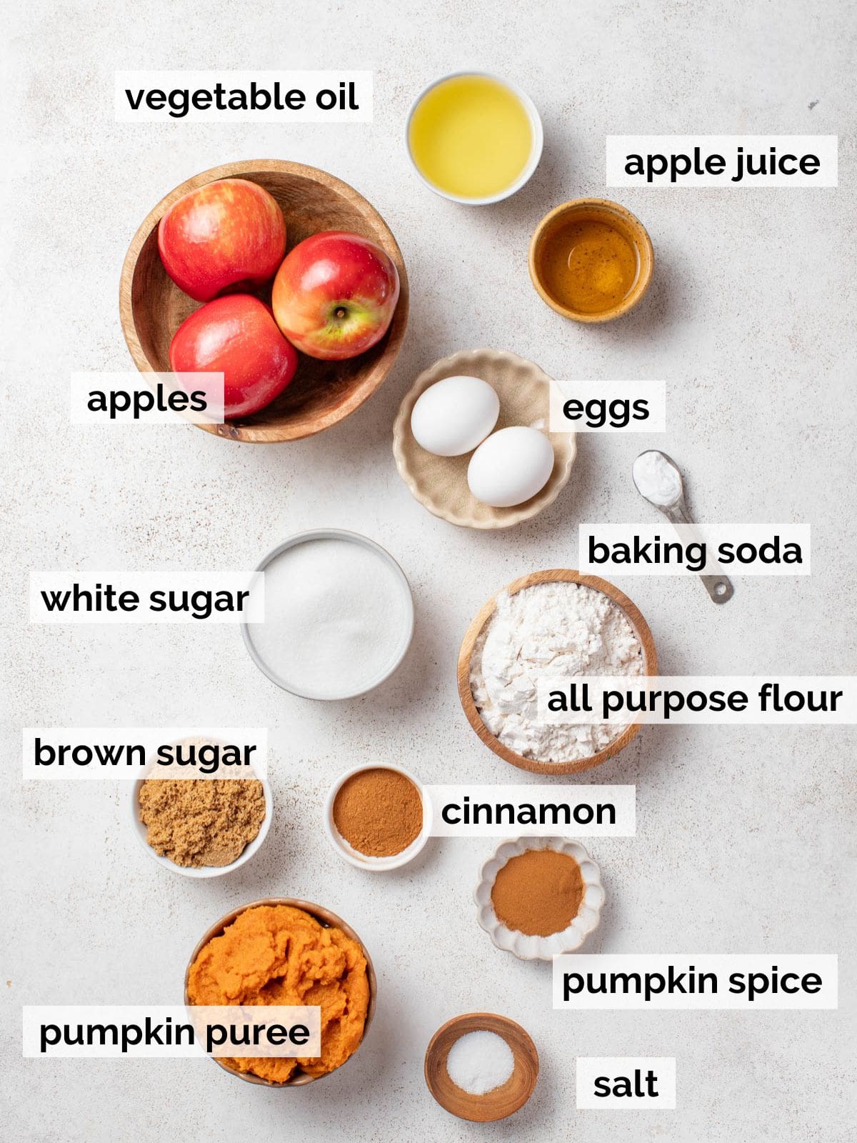 Ingredients for pumpkin bread including fresh apples, sugar, and pumpkin puree.