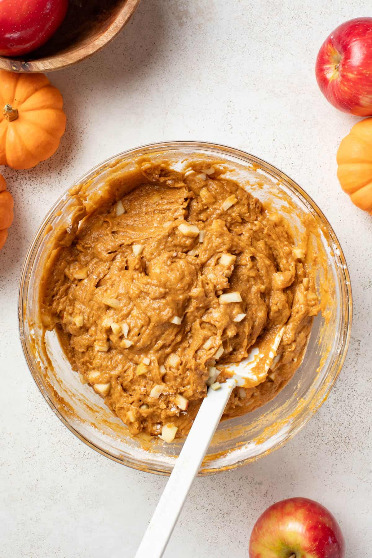 Adding apples into the pumpkin dough mixture.