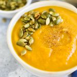 A bowl of autumn squash soup topped with pepitas