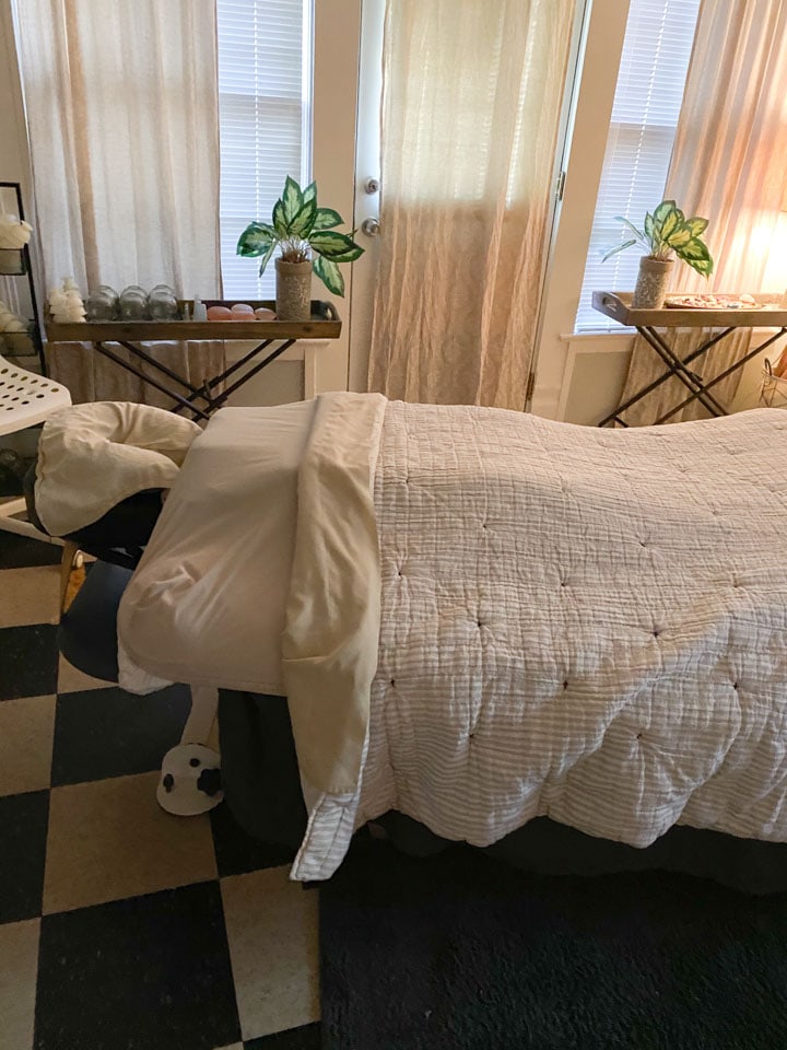 A massage table in a cozy low-lit room