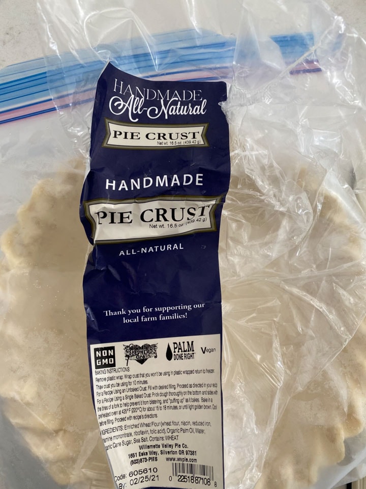 A frozen pie crust being unwrapped