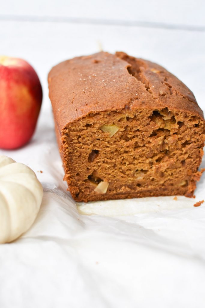 A baked pumpkin apple bread sliced so you can see the apples inside