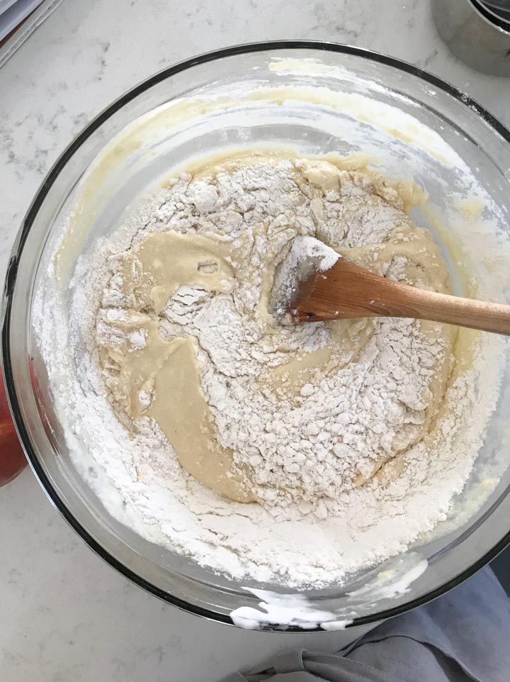 A mixing bowl with flour being mixed into cake batter