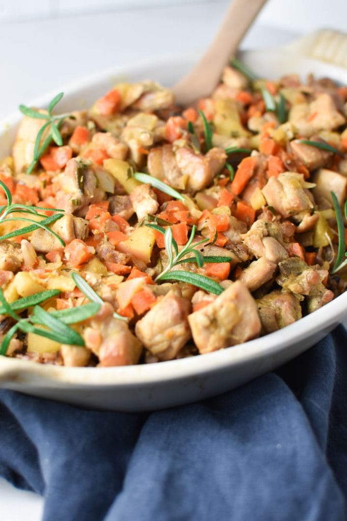 Close up of cooked chicken and wild rice in a white dish