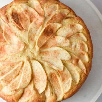A french apple cake on a white marble serving plate