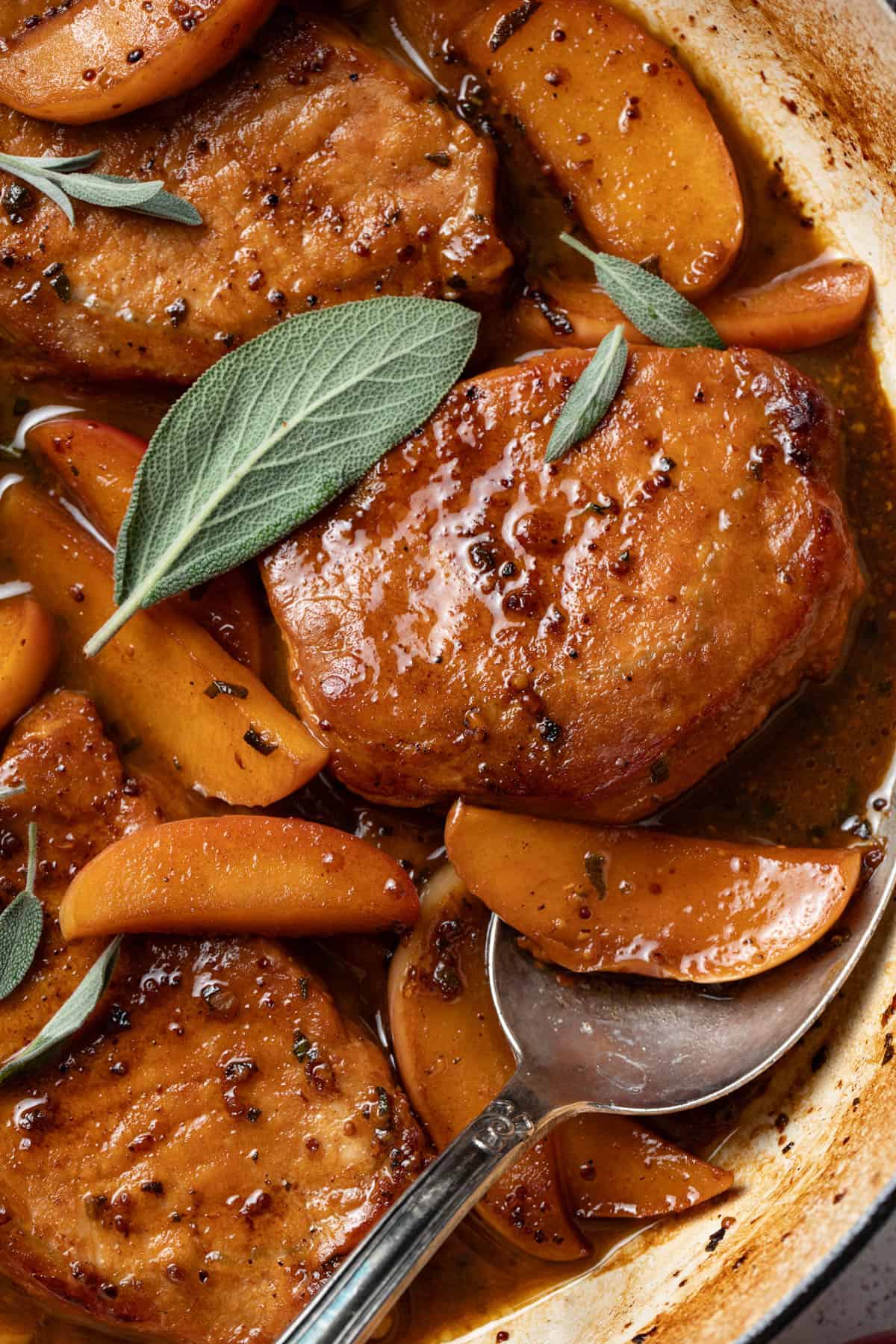 A close up shot to show seared boneless pork chops with apples and sage.