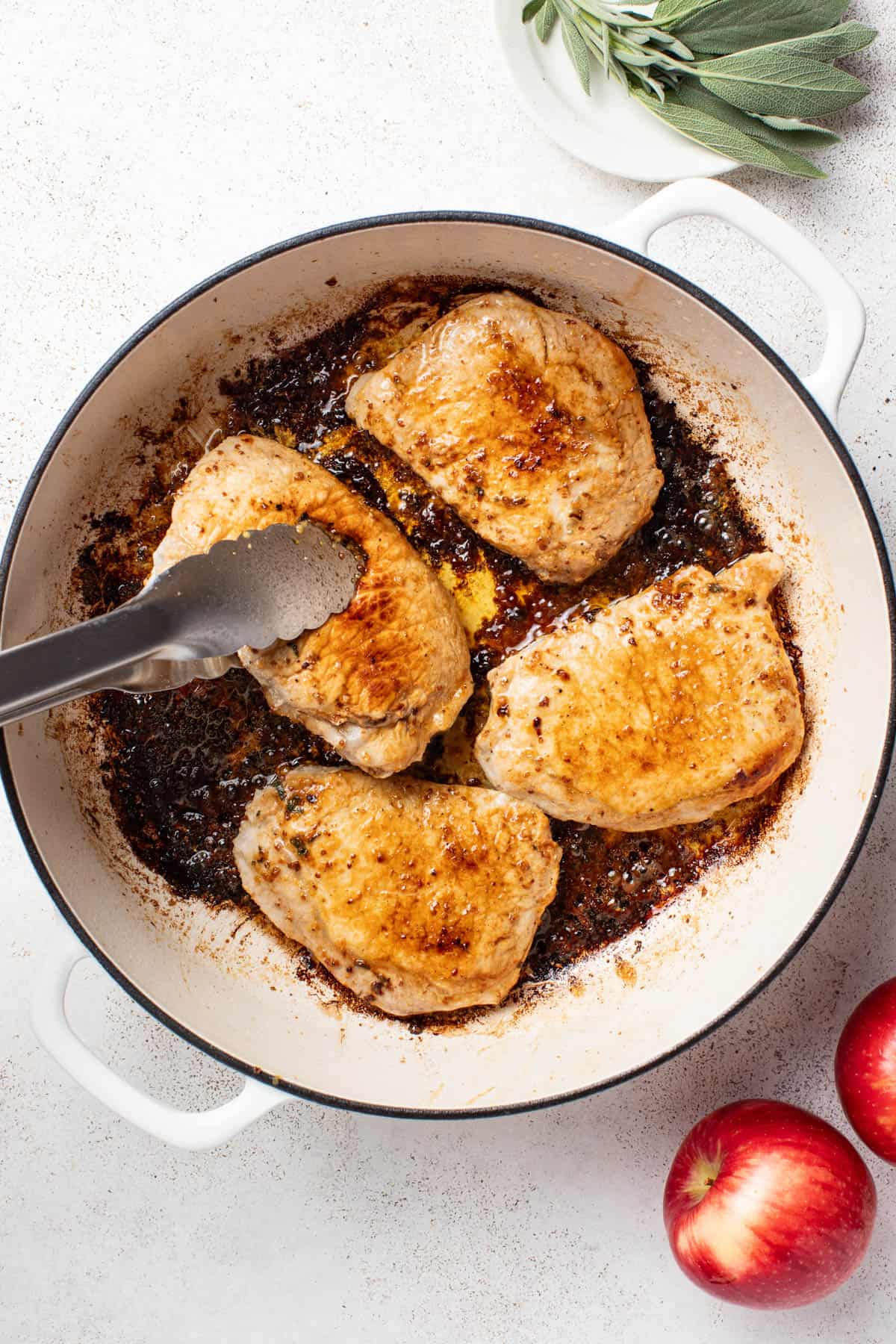 Searing pork chops in a cast iron dutch oven pan.