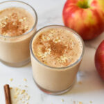Apple oatmeal smoothies with oats and cinnamon on top.
