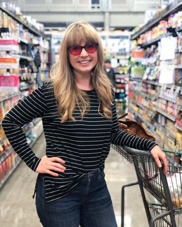 A woman in a grocery store wearing Theraspecs Audrey Lenses.