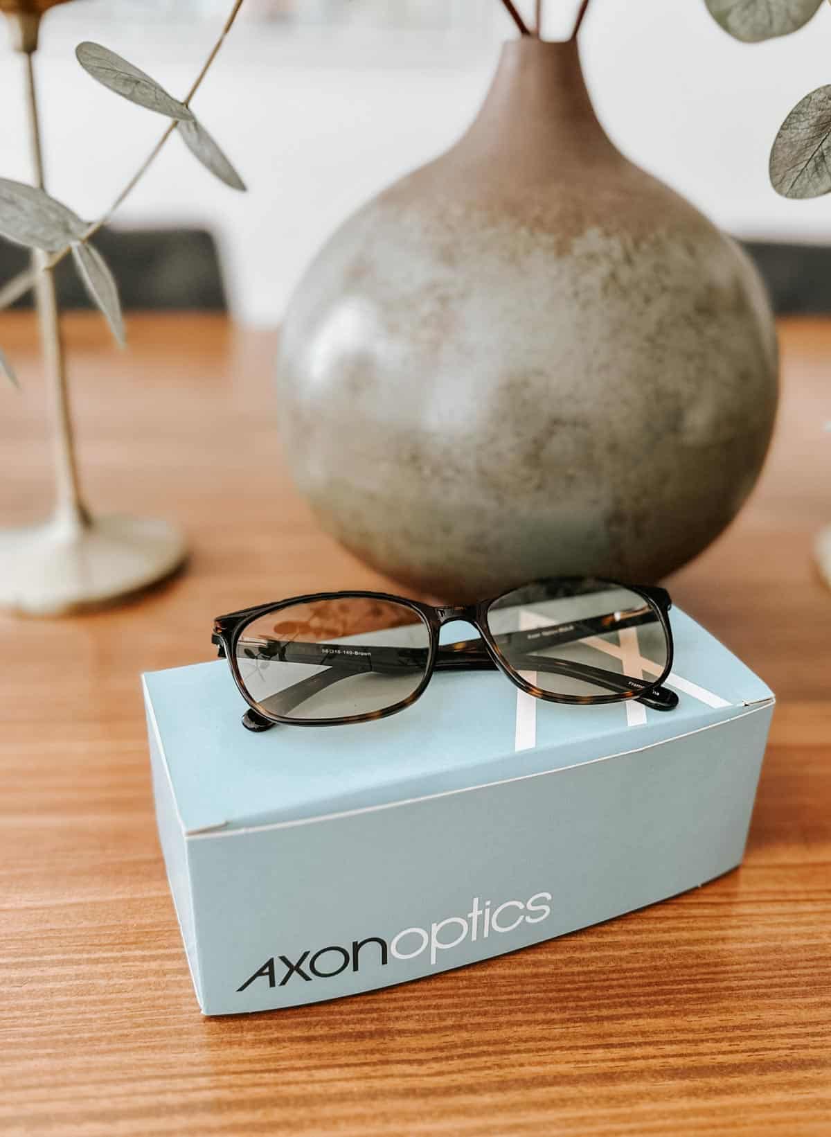 A pair of Axon glasses on a blue package. 