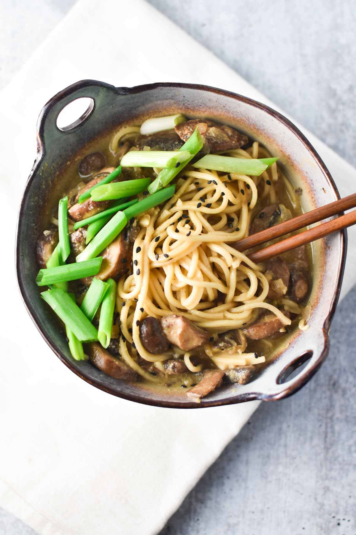 Vegan ramen in a bowl topped with scallions and mushrooms