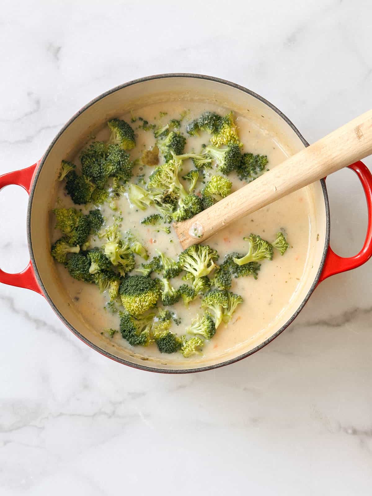 Stirring fresh broccoli into the cheese soup.