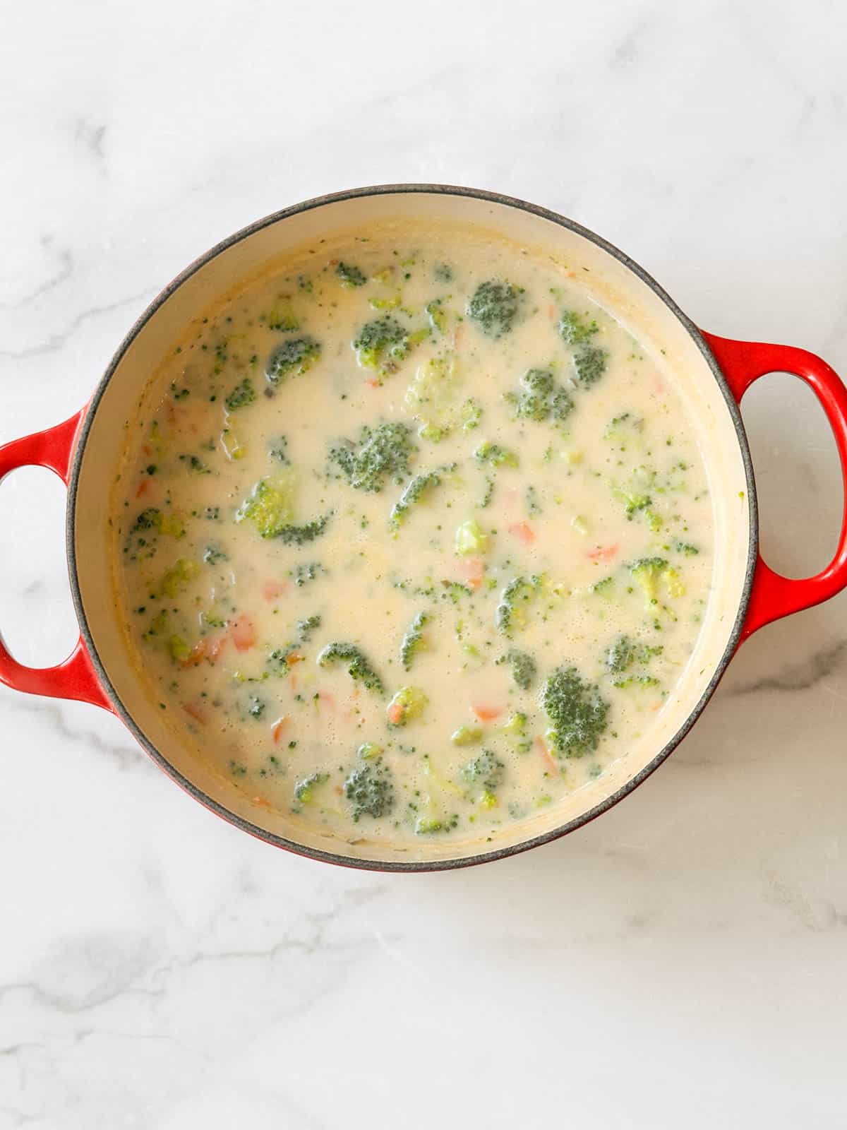 Adding Boursin cheese to the soup.