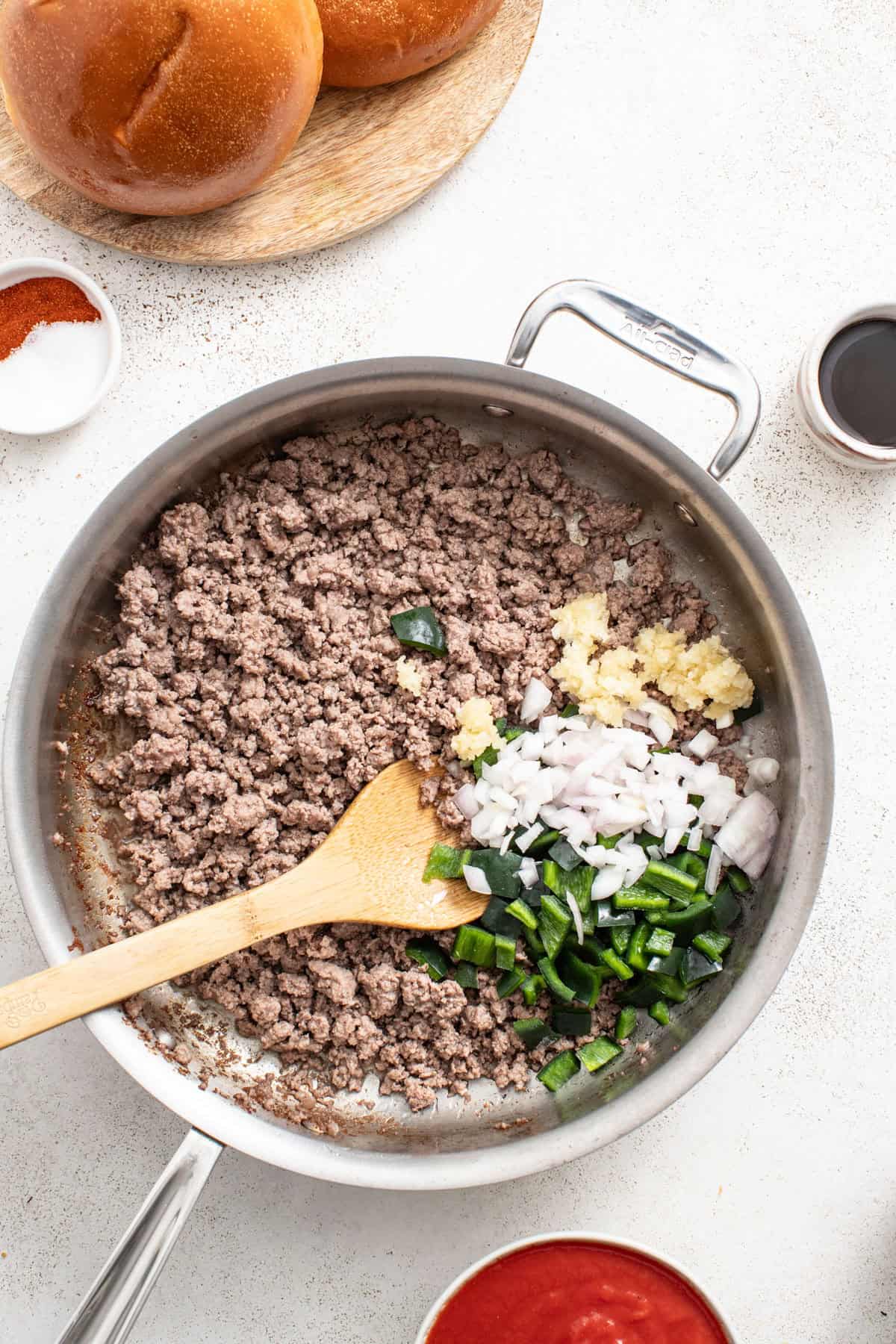 Ground beef, peppers, garlic and shallots in a pan.