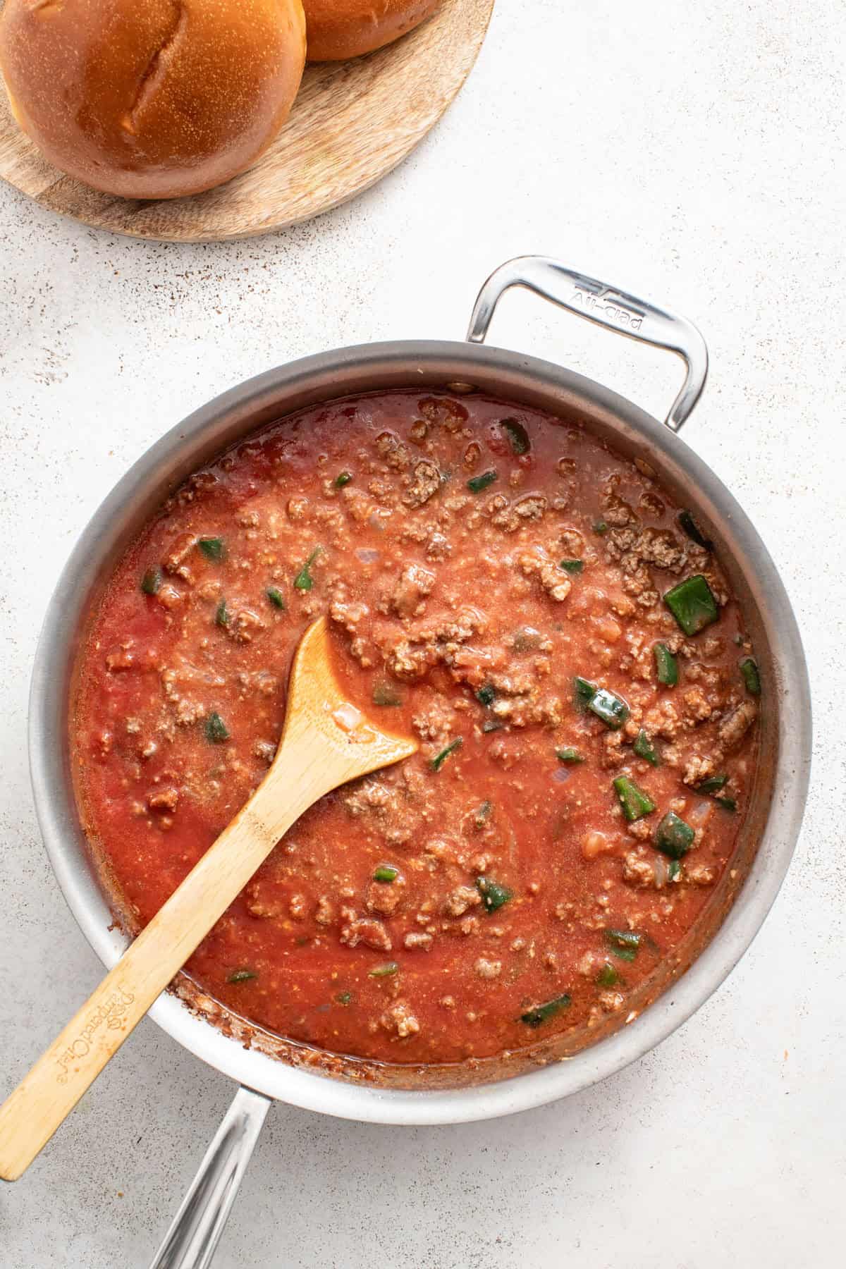 Adding tomato sauce to the pan with ground beef.
