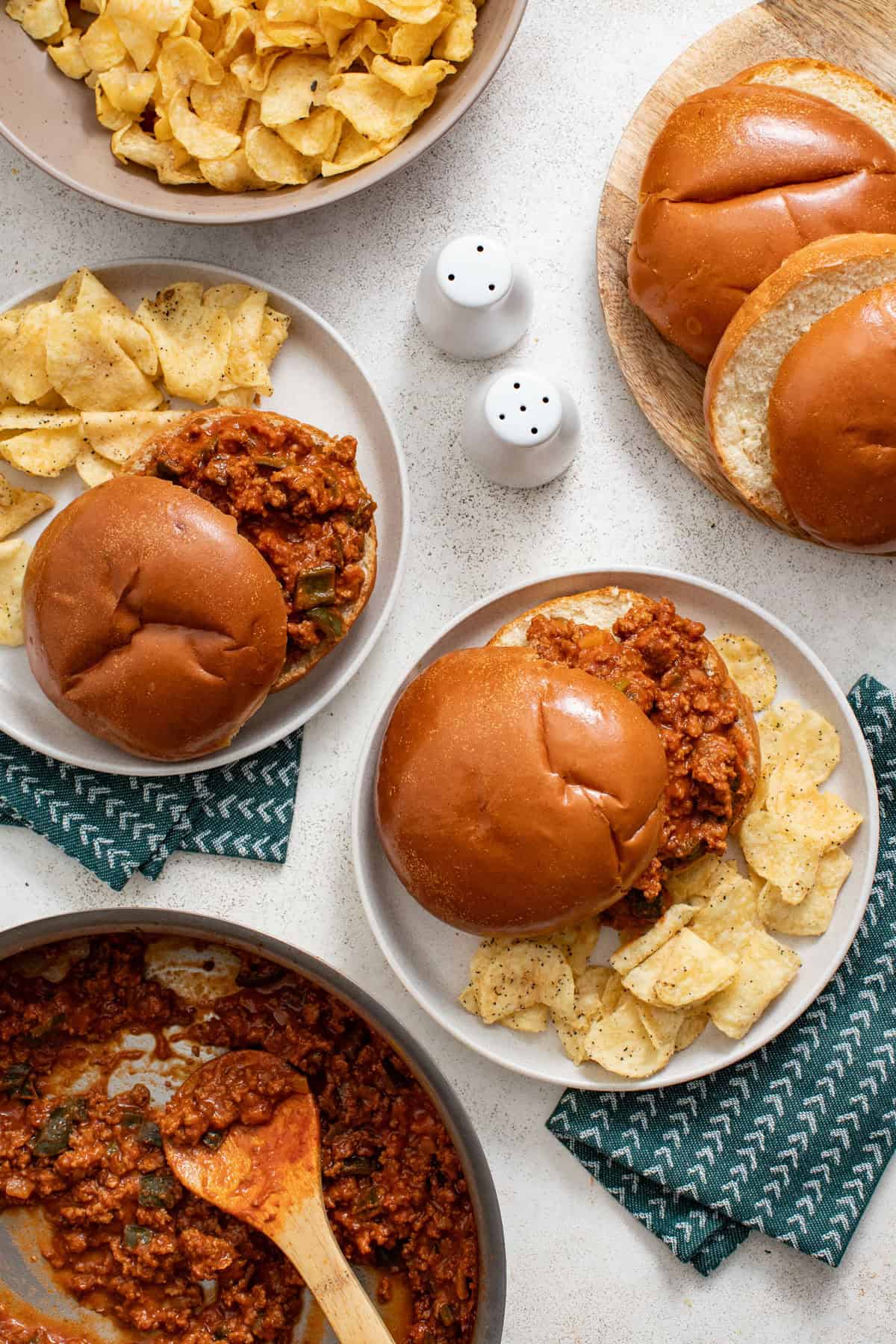 Two sloppy joe sandwiches on plates.