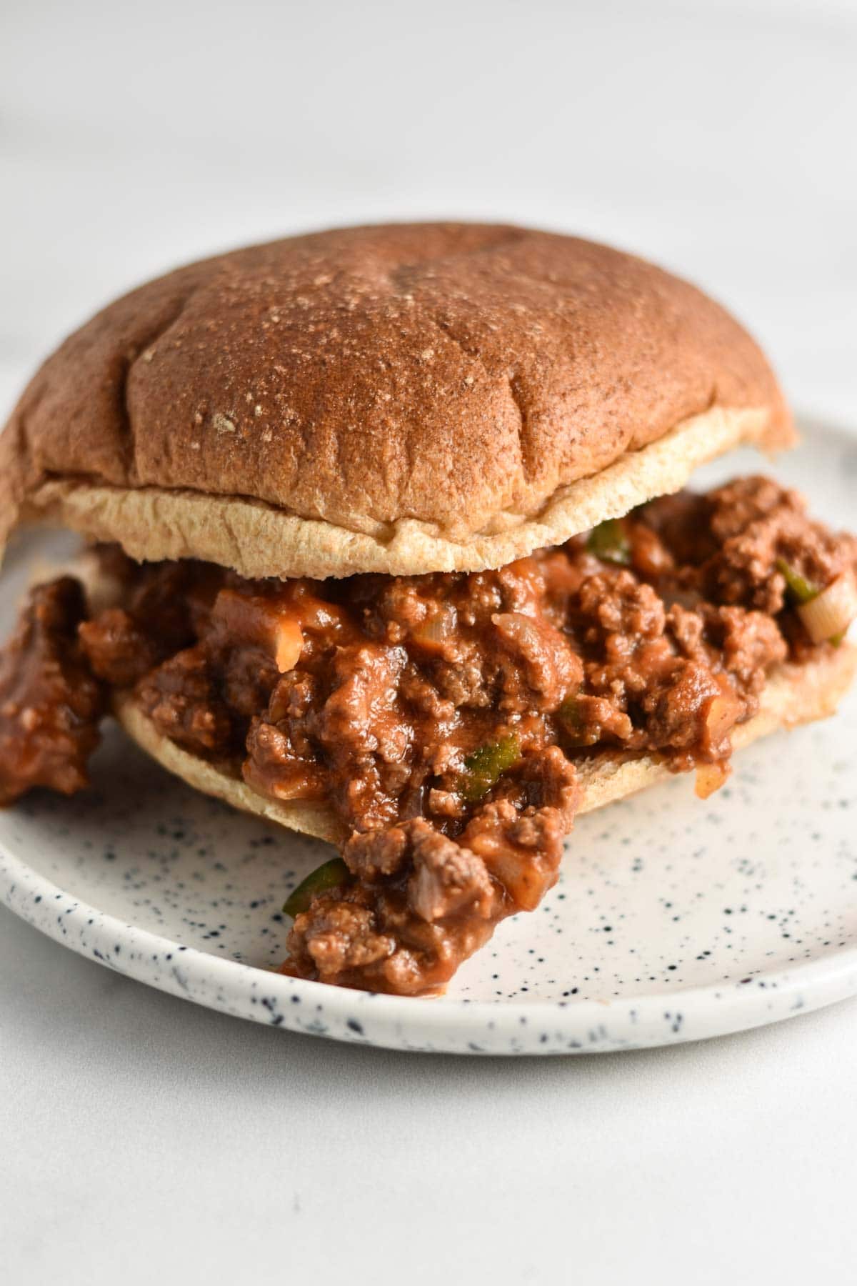 A burger bun with sloppy joe filling.