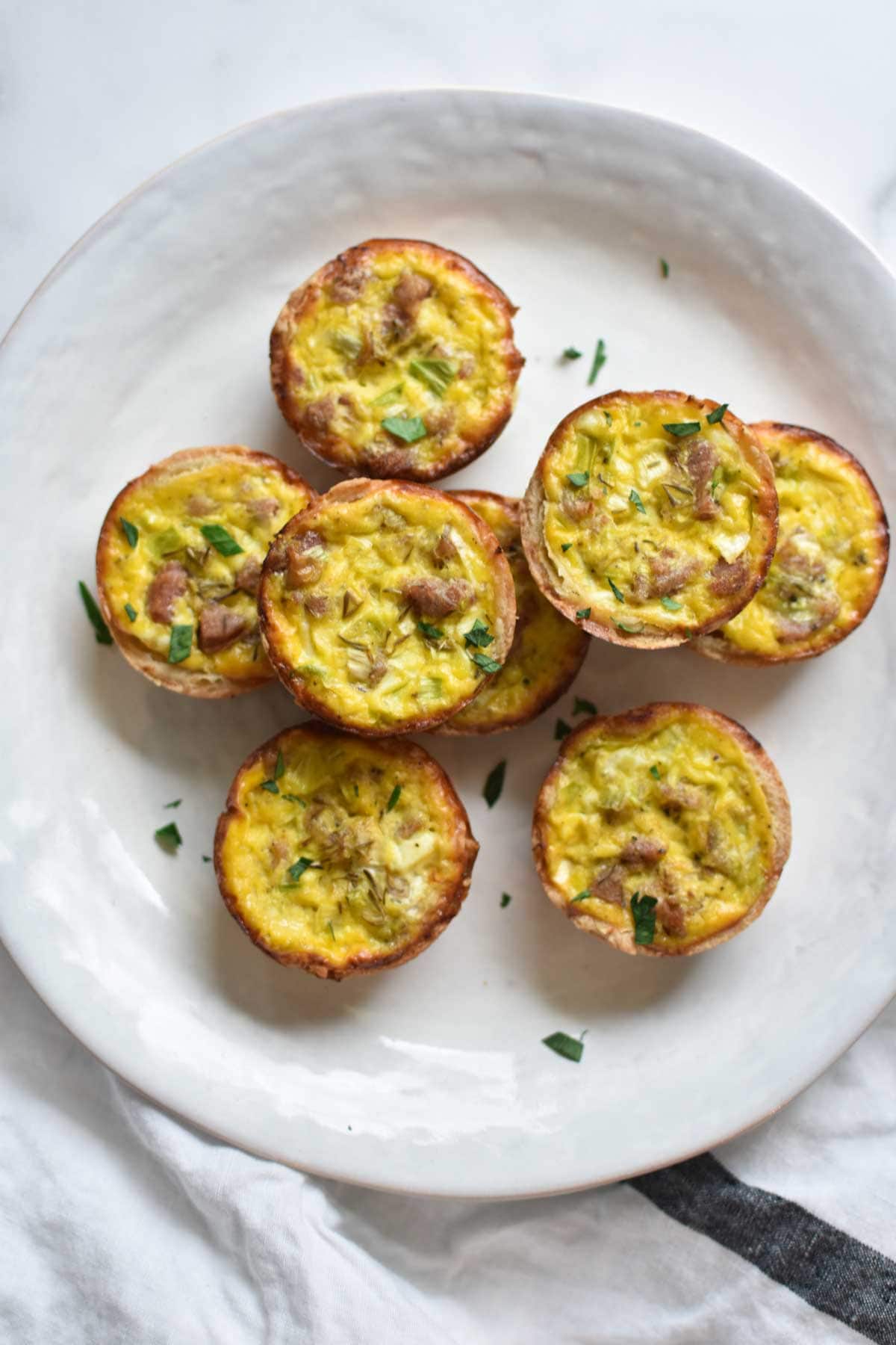 Sausage and leek dairy free quiches on a white plate