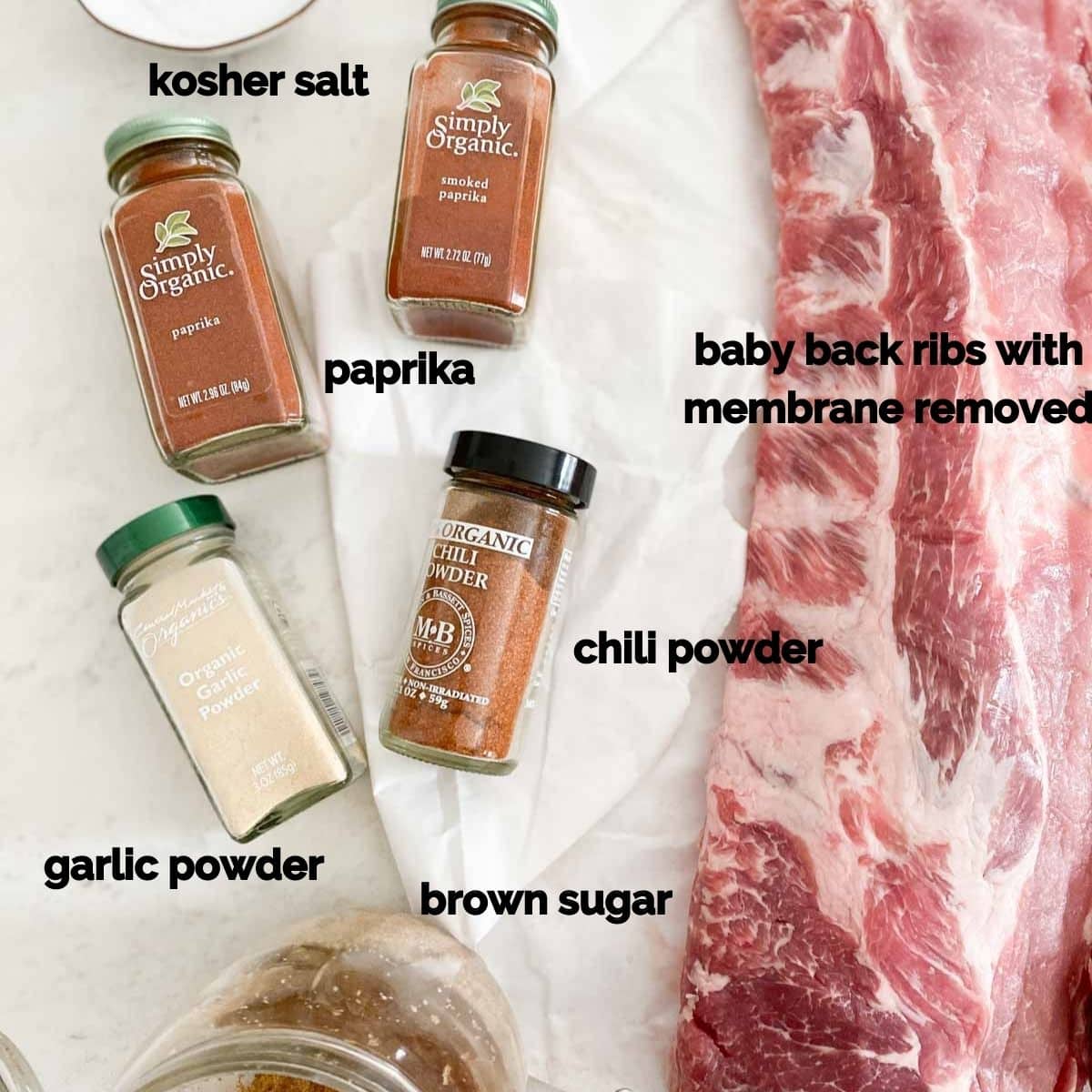 Salt, paprika, chili powder, and other dry rub ingredients for ribs on a table