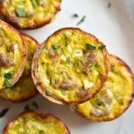 Dairy free quiche stacked on a plate with sausage and leeks