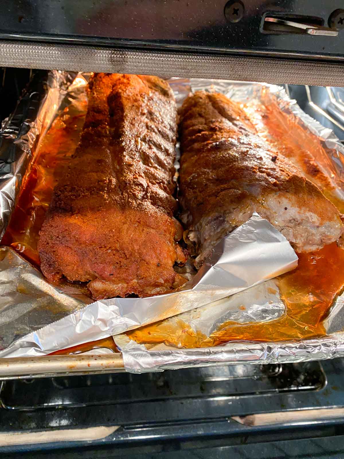 Two racks of ribs being broiled in the oven