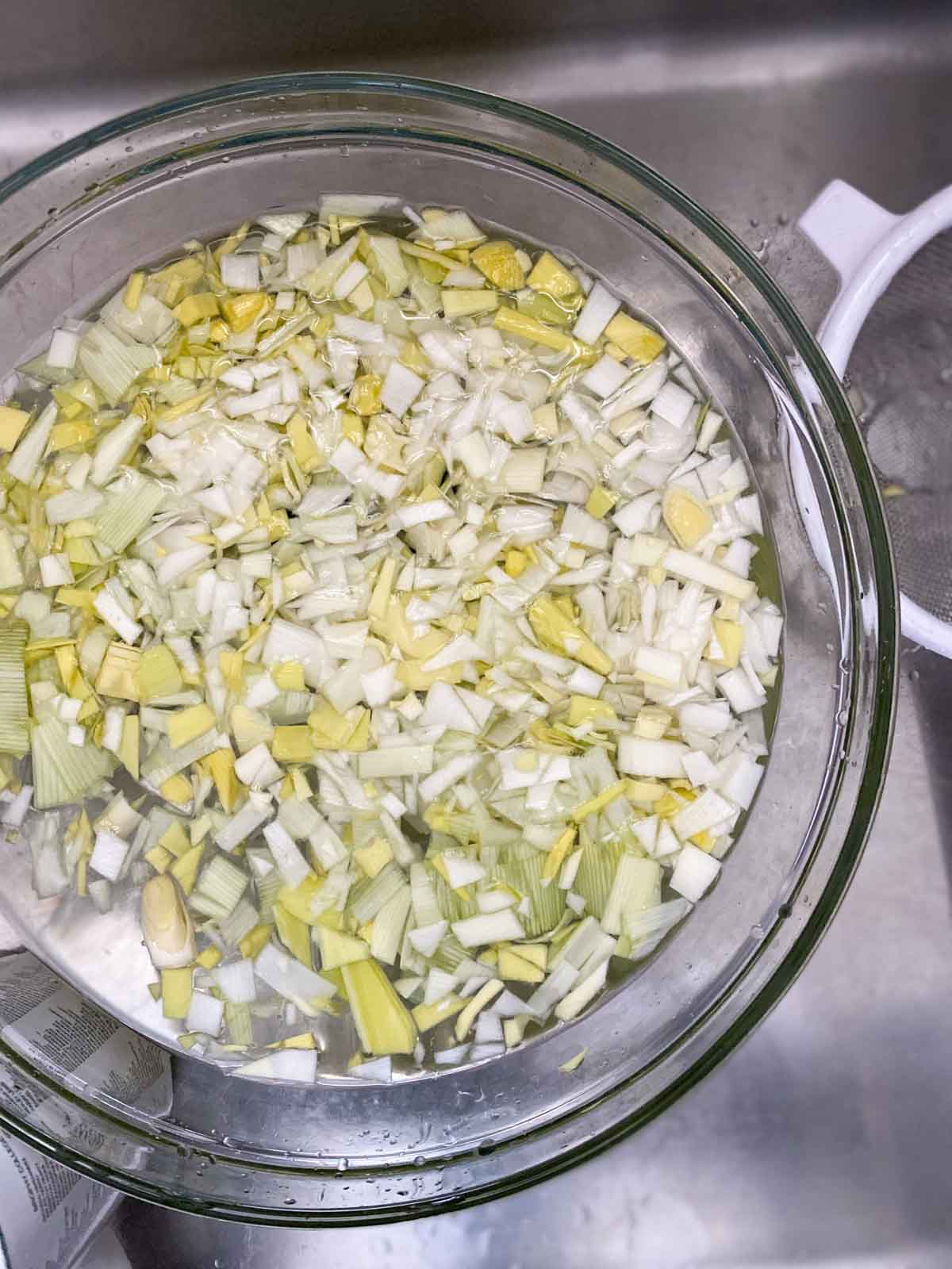 Leeks being washed in a colander