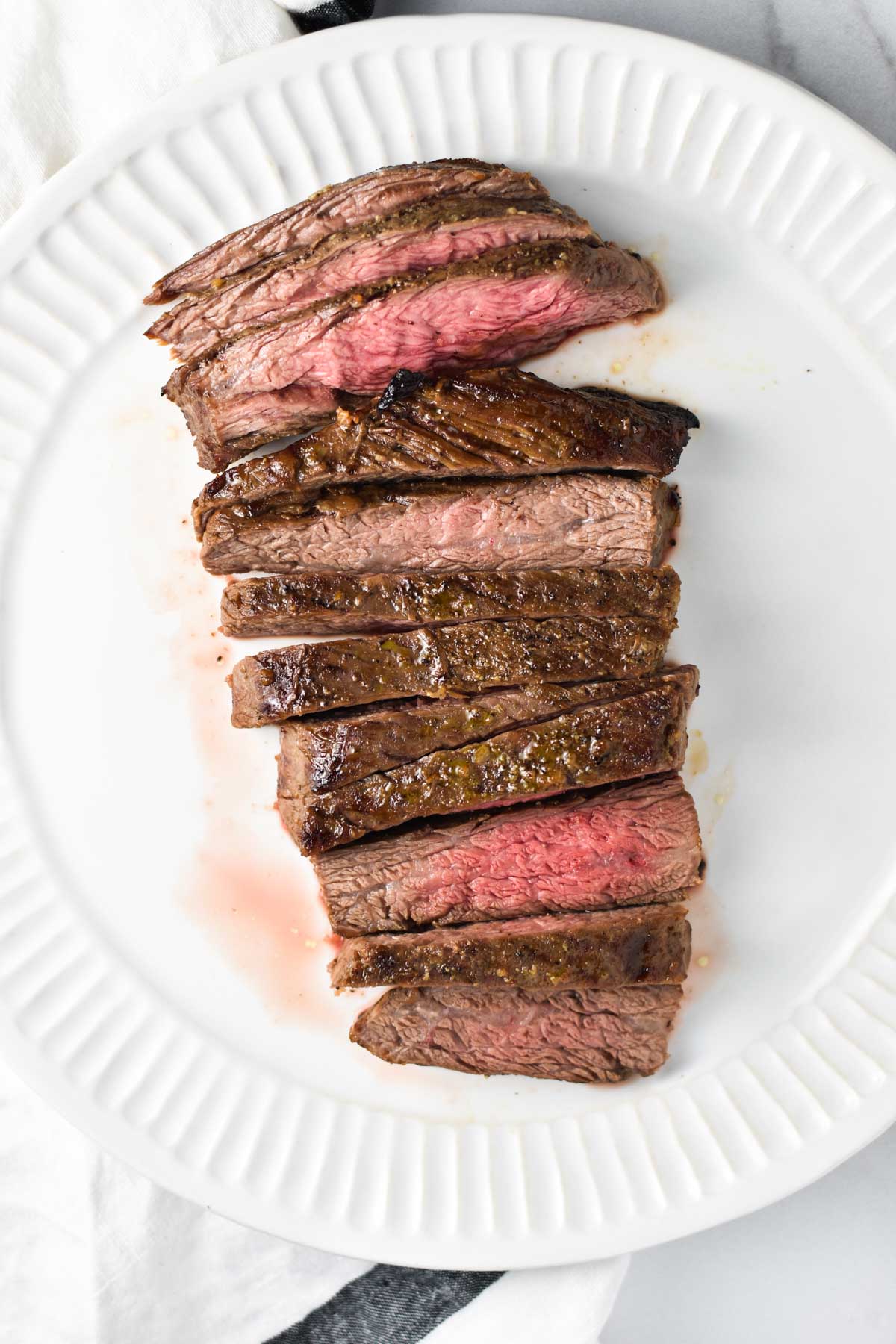 A plate of sliced flank steak showing medium and medium rare cuts.