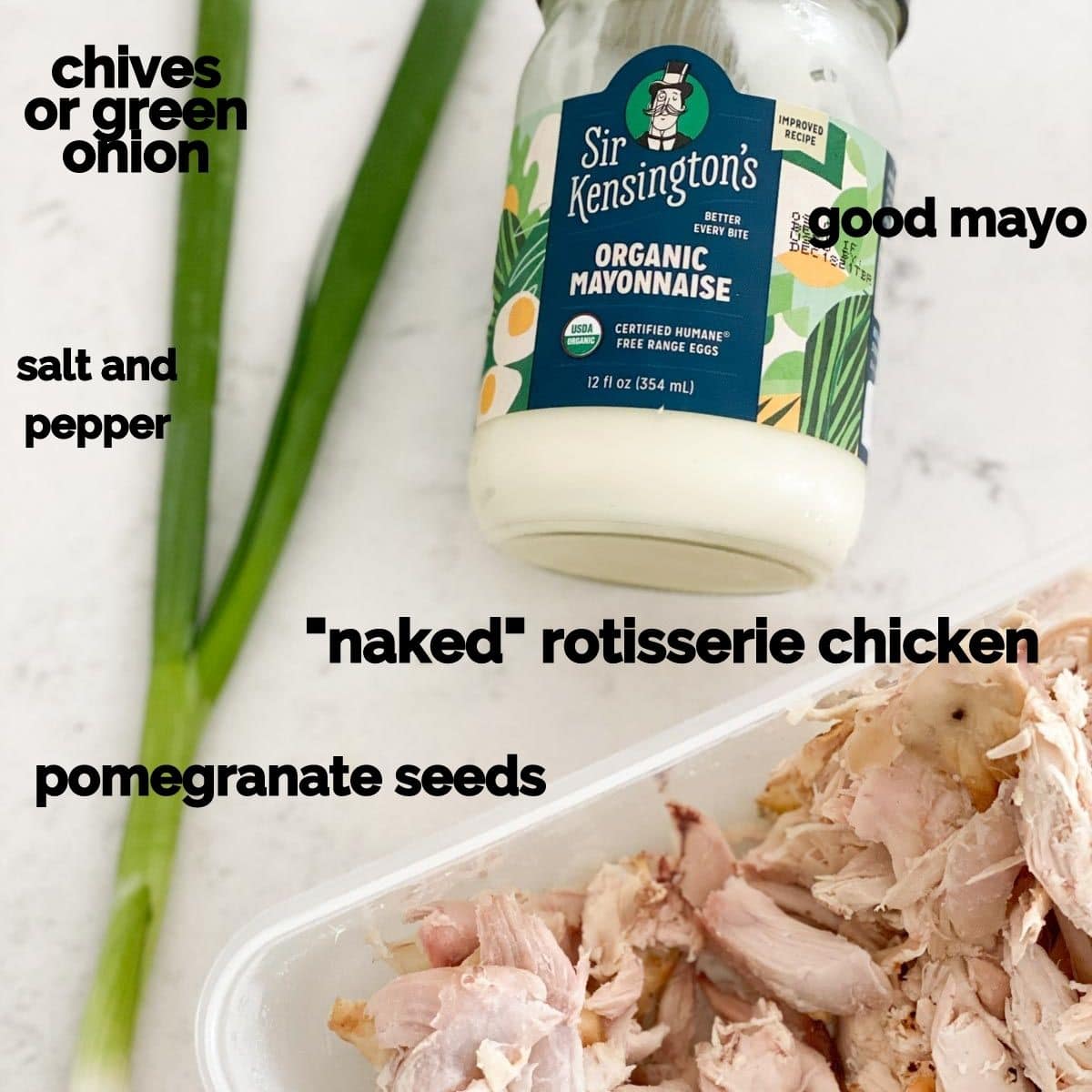 Ingredients for chicken salad like mayo, chicken, and green onion on a marble table