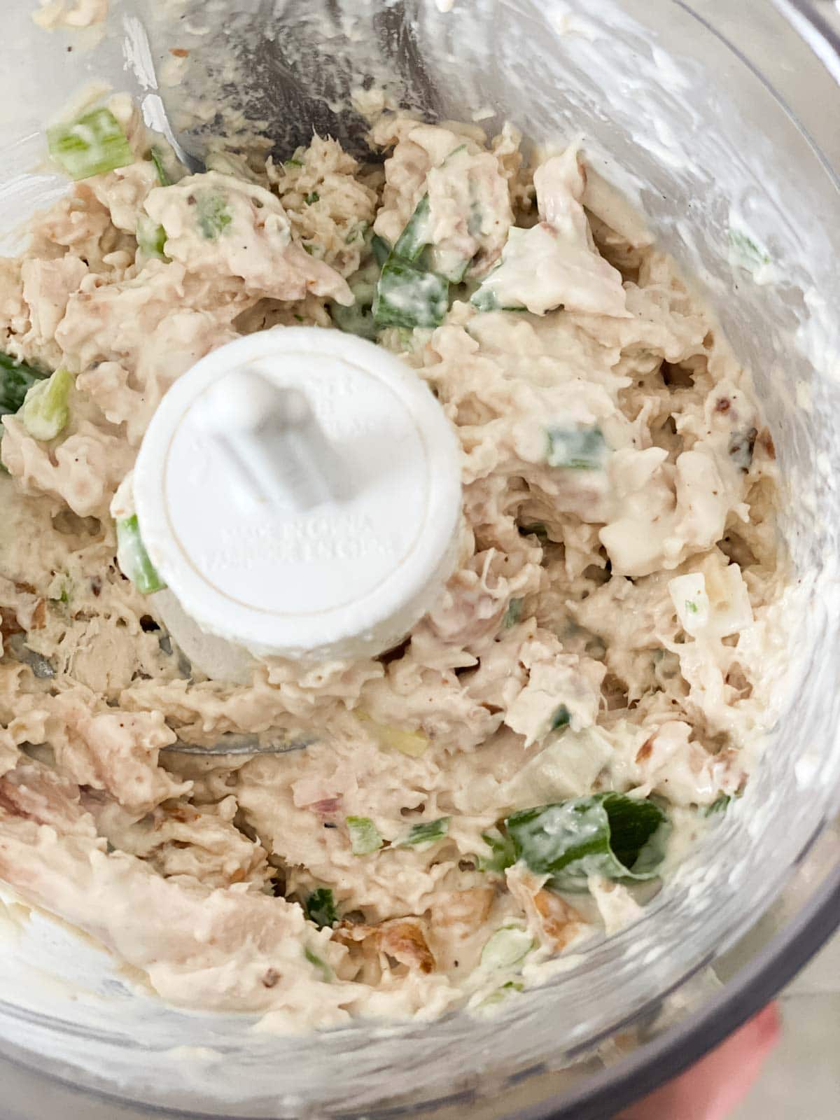 A food processor that has just chopped chicken salad