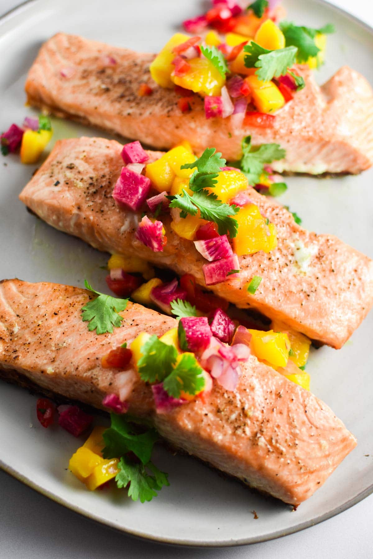 Salmon and mango salsa on a plate with cilantro