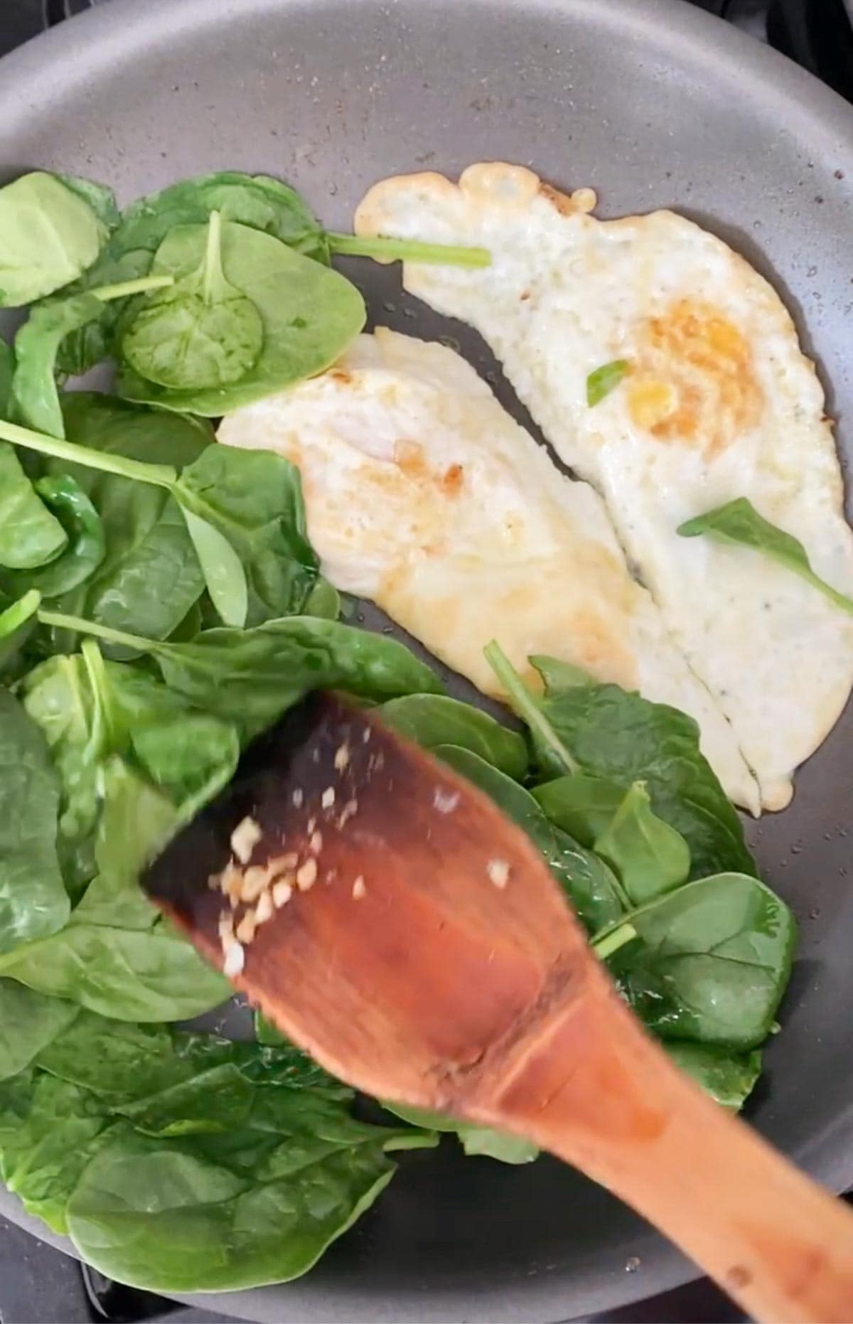 Cooking spinach and eggs together in one pan.