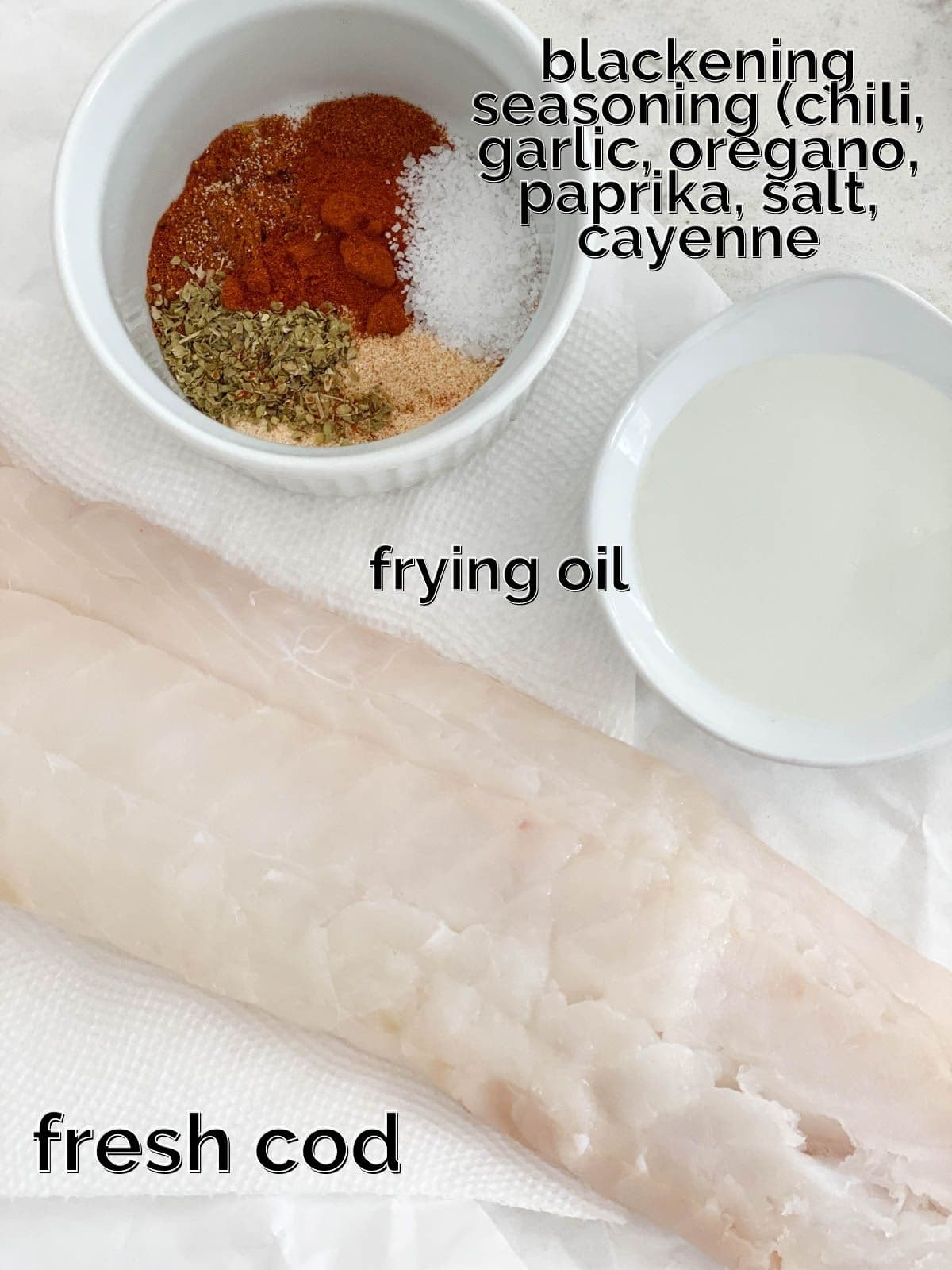 Spices, cod, and oil on a white table