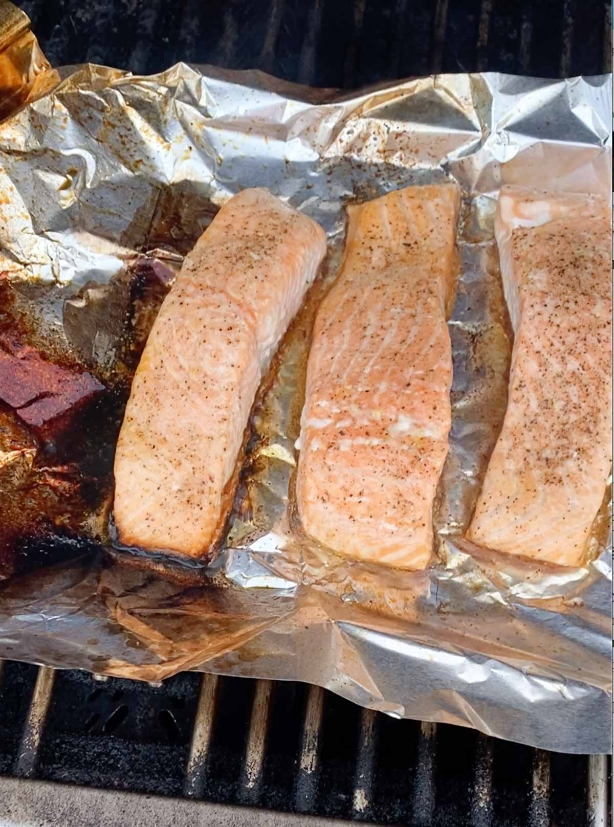 Salmon being cooked on a gas grill.