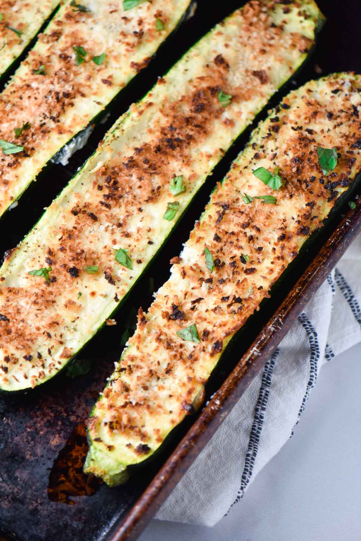 Zucchini stuffed with panko and cheese on a sheet pan