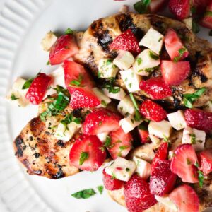 Strawberry basil chicken on a white plate topped with extra chopped basil