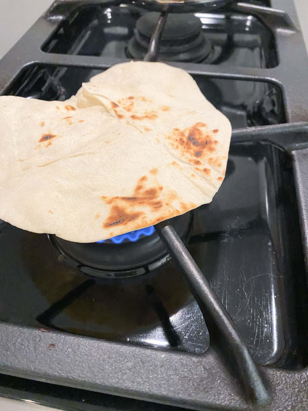 Cooking a tortilla over a gas stove