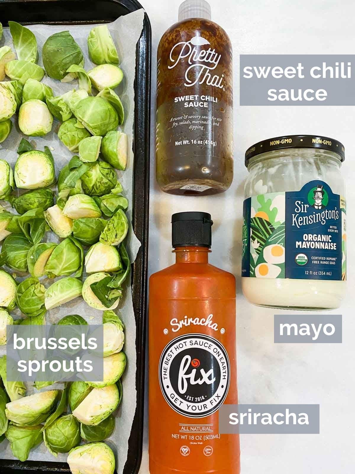 Sweet chili sauce, brussels sprouts, sriracha, and mayo on a marble table