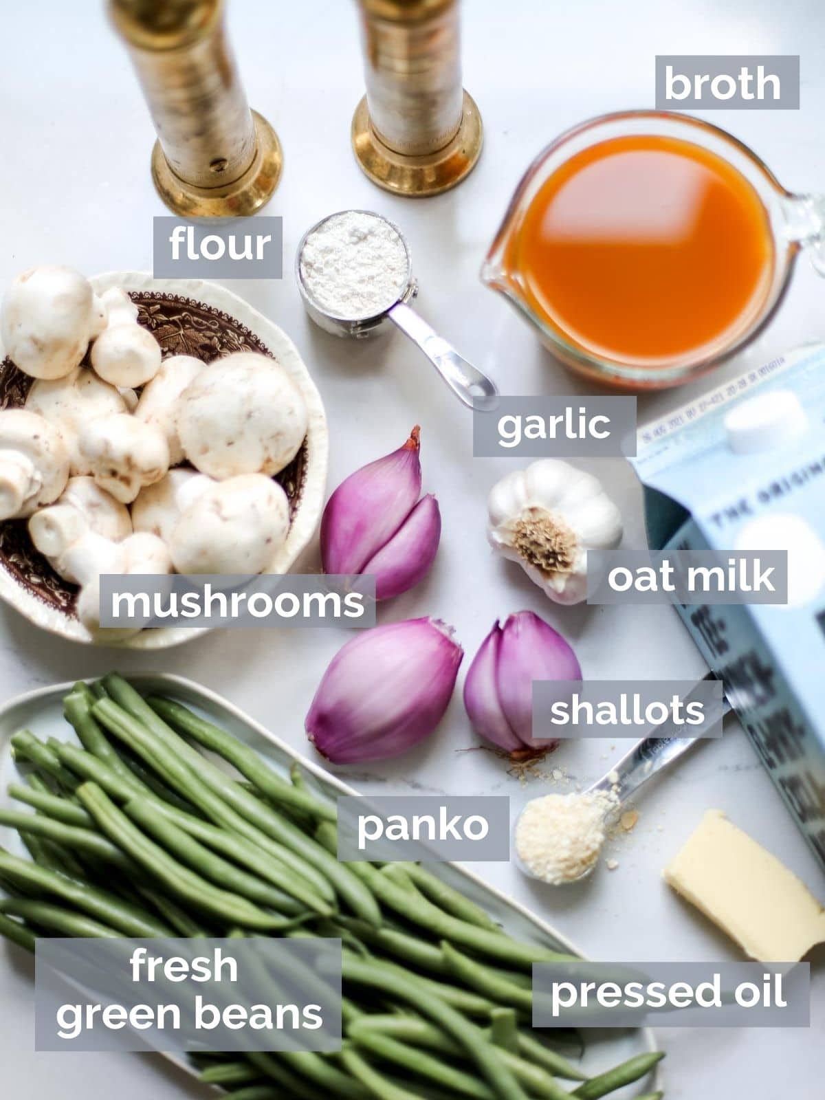 Green beans, mushrooms, broth, shallots, milk, and seasonings on a white table