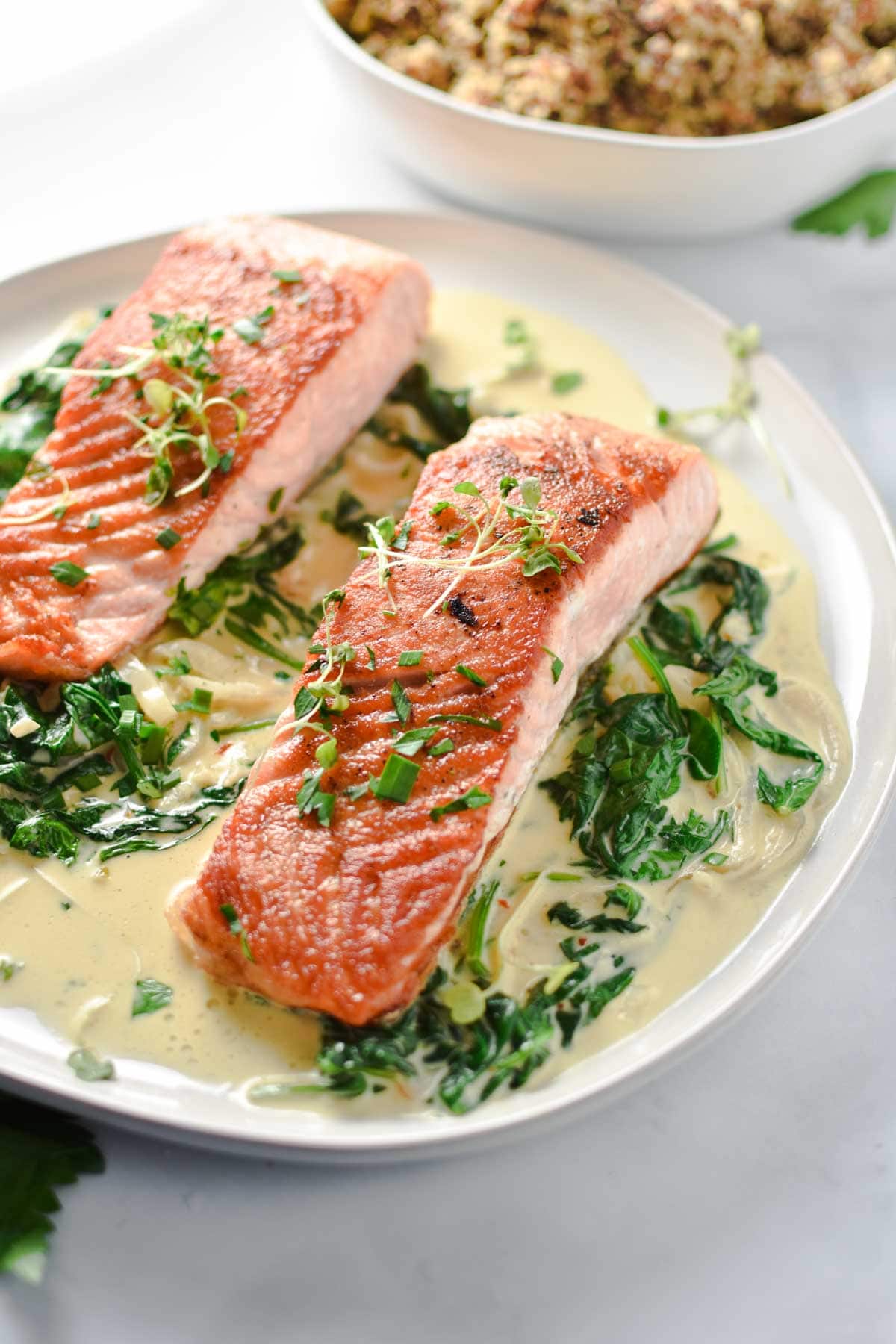 Salmon on a plate topped with parsley and microgreens