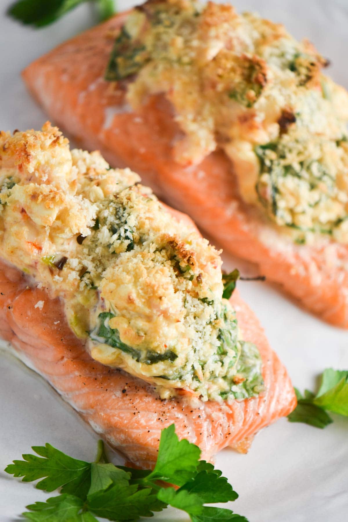 A stuffed salmon on a white plate with parsley.