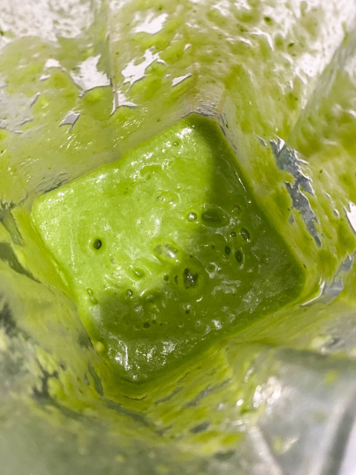A blender with a green smoothie mixture.