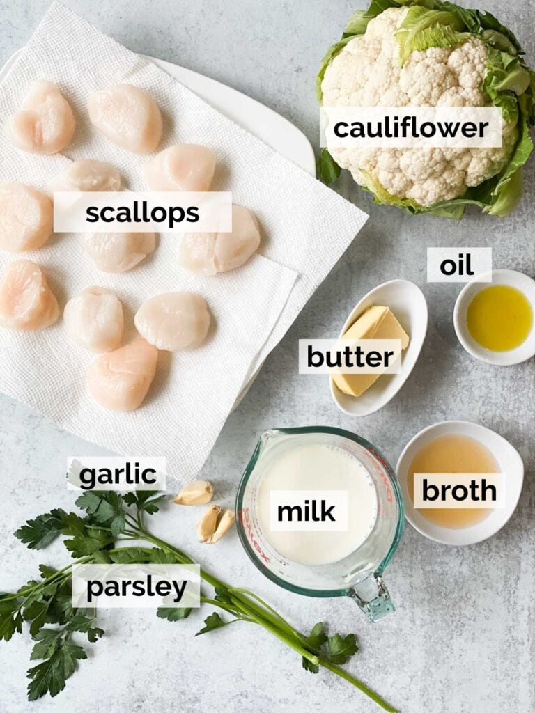 Scallops, milk, cauliflower, butter, and oil on a table.