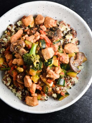A bowl of soy free chicken stir fry with broccoli, squash, rice, and chicken.