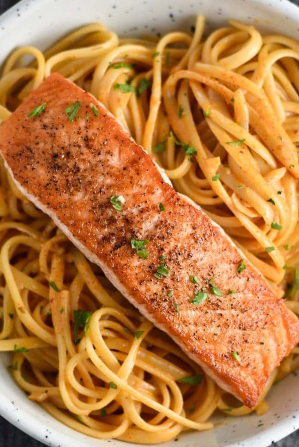 Cajun salmon pasta in a white bowl.