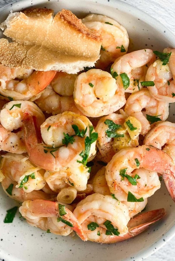 A bowl of shrimp scampi without wine and crusty bread.